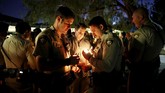 Tidak hanya warga sekitar, polisi pun ikut berbelasungkawa dan menyalakan lilin, serta berdoa. (Reuters/Chris Wattie)
