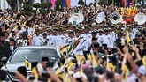 Jajaran marching band membuka jalan menuju istana, di mana sang sultan akan duduk di singgasana emas dan menjamu para tamu kehormatan. (AFP Photo/Roslan Rahman)
