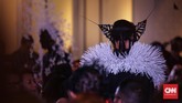 Jika topeng berwarna hitam, maka hiasan kepalanya berupa ranting, atau daun buatan berwarna putih. Begitu juga pada koleksi sebaliknya. Model yang berbusana serba putih, maka mengenakan topeng putih, tapi hiasan kepala hitam. (Foto: CNN Indonesia/Hesti Rika)