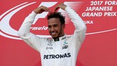 Lewis Hamilton merayakan kemenangan dengan meniru gaya selebrasi pelari jarak jauh Inggris, Mo Farah. Hamilton semakin diunggulkan menjadi juara dunia dengan empat seri tersisa. (REUTERS/Toru Hanai)