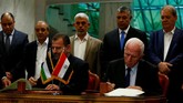 Kepala delegasi Hamas Saleh Arouri dan pemimpin Fatah Azzam Ahmad menandatangani kesepakatan rekonsiliasi di Kairo, Mesir, 12 Oktober 2017. (REUTERS / Amr Abdallah Dalsh).