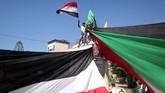Warga Palestina mengibarkan bendera Mesir dan Palestina saat mereka berkumpul di Kota Gaza untuk merayakan rekonsiliasi Hamas dan Fatah. (AFP PHOTO / MAHMUD HAMS).