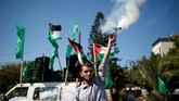 Seorang pria Palestina melepaskan kembang api ke udara saat perayaan rekonsiliasi Hamas-Fatah. (REUTERS / Suhaib Salem).