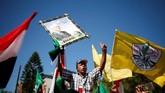 Seorang pria memegang gambar Presiden Palestina Mahmoud Abbas saat perayaan menyambut rekonsiliasi Hamas dan Fatah. (REUTERS / Suhaib Salem).