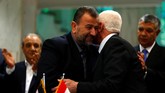 Kepala delegasi Hamas Saleh Arouri memeluk pemimpin Fatah Azzam Ahmad saat mereka menandatangani kesepakatan damai di Kairo, Mesir, 12 Oktober 2017. (REUTERS / Amr Abdallah Dalsh).