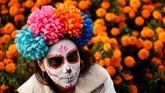 Ribuan orang memenuhi jalan-jalan di kota Meksiko untuk sebuah perayaan. Namun mereka tak menggunakan baju pesta dan berdandan cantik untuk pesta ini. (REUTERS/Carlos Jasso)