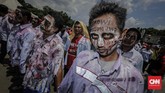 Para zombie itu melakukan aksi teatrikal menggendong pocong di jalan raya, menggeliat dan meringkuk sebagai simbol matinya kesejahteraan buruh Pertamina. (CNN Indonesia/Adhi Wicaksono).