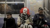 Pria mengenakan kostum badut seram 'It' menumpang kereta bawah tanah di Manhattan, Amerika Serikat. (REUTERS/Elizabeth Shafiroff)