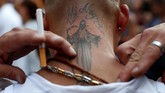 Sebagian masyarakat menghargai orang suci atau pun dewa dalam kepercayaan mereka dengan cara merajah tubuh, seperti yang dilakukan pria Meksiko yang memiliki tato Santa Muerte ini. (REUTERS/Carlos Jasso)