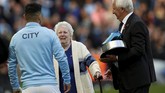 Sergio Aguero mendapat penghargaan dari legenda Manchester City Mike Summerbee (kanan) dan putri dari legenda ManCity Eric Brook, Betty Cowgill. (Action Images via Reuters/Lee Smith)