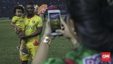 Pemain Bhayangkara FC Guy Junior melakukan selebrasi dengan melakukan selfie dengan sang anak usai pertandingan melawan Persija Jakarta. (CNNIndonesia/Adhi Wicaksono)