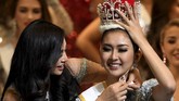 Usai dipasangi mahkota, Kylie Verzosa juga mengalungkan jubah kemenangan. Kevin masih tampak tak percaya dan berusaha menahan mahkota yang ada di atas kepala.(AFP PHOTO / Toshifumi KITAMURA)