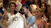 Kevin tak kuasa menahan haru saat namanya disebut sebagai pemenang, unggul dari kontestan asal Curacao, Venezuela, Australia dan Jepang di urutan Top 5. Ia memeluk erat Miss Internatinal 2016 asal Filipina, Kylie Verzosa. (AFP PHOTO / Toshifumi KITAMURA)