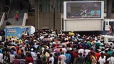 Rakyat Zimbabwe menyaksikan peristiwa pelantikan Presiden barunya Emmerson Mnangagwa dari layar di luar Stadion Olahraga Nasional, Harare, Jumat (24/11). (AFP PHOTO/Zinyange AUNTONY)