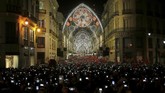 Pengunjung mengarahkan kamera telepon genggamnya saat lampu penanda datangnya Natal dinyalakan di kawasan Marques de Larios, Malaga, selatan Spanyol. (REUTERS/Jon Nazca)