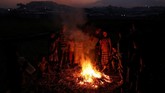 Anak-anak Rohingya bermain di depan api unggung di pemukiman pengungsi Jamtoli, dekat Cox's Bazar, Bangladesh, 24 November 2017. (REUTERS/Susana Vera TPX IMAGES OF THE DAY)