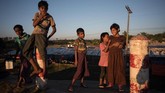 Anak-anak pengungsi Rohingya bermain di tepi jalan kamp pengungsi Shamlapur, Cox's Bazar, Bangladesh, 1 Desember 2017 lalu. Sekitar 620 ribu etnis Rohingya mengungsi ke Bangladesh sejak Agustus dan terus mengalir meski kesepakatan pemulangan mereka telah diteken bersama Myanmar. (AFP PHOTO / Ed JONES)