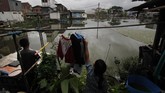 Seorang anak menjemur baju di kawasan Kapuk Teko, Cengkareng, Jakarta Barat pada tanggal 30 November 2017.(Anadolu Agency/Eko Siswono Toyudho)