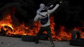 Sementara warga ini melemparkan batu ke arah pasukan Israel di lokasi yang sama. (REUTERS/Mohamad Torokman)