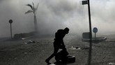 Demonstran warga Palestina ini berlari menyelamatkan diri di tengah bentrokan di dekat permukiman Yahudi di Beit El, dekat Ramallah. (REUTERS/Mohamad Torokman)