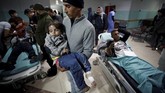 Seorang penduduk Palestina menggendong putrinya yang terluka di rumah sakit di Gaza bagian utara. Pasukan keamanan Israel di Gaza menyatakan aksi itu merupakan respons atas serangan roket dari Gaza ke Israel. (REUTERS/Mohammed Salem)