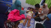 Seorang anak kecil yang selamat tertimbun reruntuhan rumah yang ambruk akibat gempa bumi dirawat oleh keluarganya di Desa Sumelap, Kota Tasikmalaya. Akibat gempa, seorang warga Ciamis dan seorang Pekalongan meninggal, sementara tujuh orang lainnya dari berbagai daerah menderita luka-luka. (Antara/Adeng Bustomi)