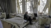 Mohammed Mohiedin Anis alias Abu Omar, 70 tahun, merokok dengan tenang sambil duduk mendengarkan musik di kamar tidurnya yang hancur berantakan di bekas kawasan yang dikuasai pemberontak, Al-Shaar, Aleppo, Suriah. (AFP PHOTO / JOSEPH EID)