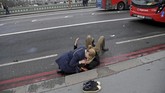 Seorang wanita membantu korban luka-luka dalam serangan teror di Jembatan Westminster London, Inggris, 22 Maret 2017. Empat orang tewas termasuk pelaku, sedikitnya 40 luka-luka. (REUTERS/Toby Melville)
