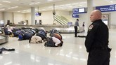 Umat muslim sembahyang di lokasi pengambilan bagasi sebagai protes atas larangan bepergian yang berlaku akibat perintah eksekutif dari Presiden Amerika Serikat Donald Trump di Bandara International Fort Worth, Dallas, Texas, 29 Januari 2017. (REUTERS/Laura Buckman)