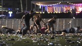 Orang-orang berlarian menyelamatkan diri saat pelaku menembaki para penonton festival musik dari atas Hotel dan Kasino Mandalay Bay, sebuah resort di Las Vegas, Nevada, AS, Minggu, 1 Oktober 2017. Sedikitnya 58 tewas dan 515 luka-luka. David Becker/Getty Images/AFP