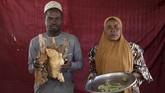Begitu sulitnya kehidupan di kamp berpopulasi 21 ribu orang tersebut, seorang bapak rela menggadai deterjen yang ia beli dari hasil jerih payahnya bekerja sebagai pengangkut barang untuk ditukar dengan kacang tanah. (Reuters/Afolabi Sotunde)