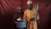 Seikat kayu bakar bisa ditukar dengan susu. Sementara itu, semangkuk ikan kecil merupakan tawaran menarik bagi pemilik minyak masak. (Reuters/Afolabi Sotunde)