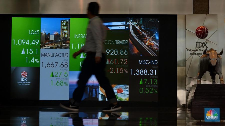 Karyawan melintas di depan papan elektronik buursa efek Indonesia