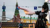 Seorang seniman jalanan di jalan Tverskaya, tepatnya di depan Istana Kremlin, Moskow, mengangkat tangan raksasanya dalam festival menyambut natal dan tahun baru. Rusia sendiri merayakan natal kristen ortodoks pada 7 Januari. (AFP PHOTO / Mladen ANTONOV)