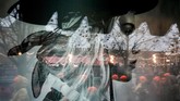 Bayangan para pejalan kaki tercermin di iklan parfum pada sebuah gelas kaca pusat perbelanjaan GUM di Red Square, Moskow, Rusia. (AFP PHOTO / Yuri KADOBNOV)
