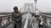 Badai salju juga menyebabkan ribuan penerbangan ditangguhkan atau dibatalkan. Para pejalan kaki harus berjuang melintasi angin bersalju di Jembatan Brooklyn saat Badai Salju Grayson melanda Kota New York, Amerika Serikat, 4 Januari 2018. (REUTERS/Darren Ornitz)