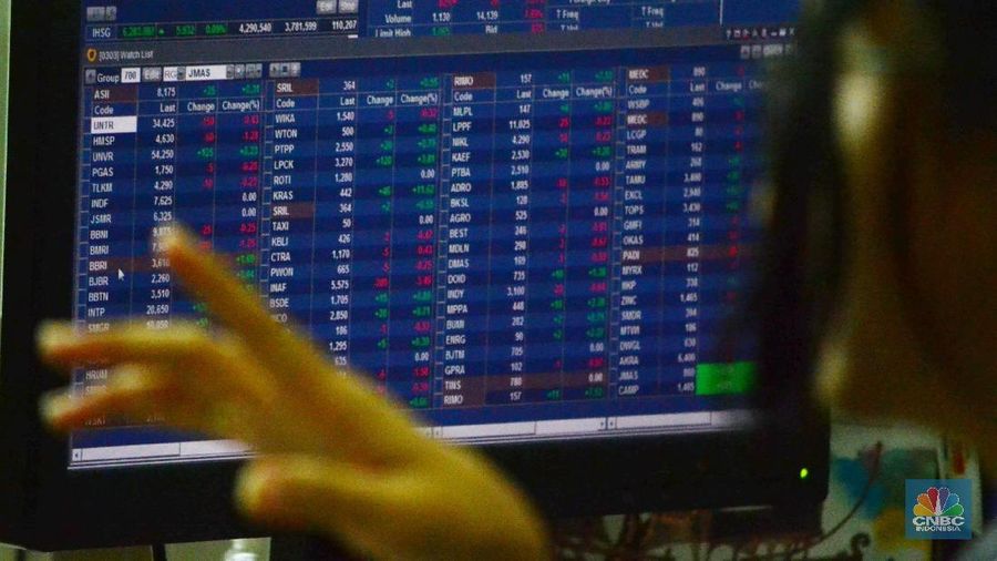 Pengunjung melintas dan mengamati pergerakan layar elektronik di di Jakarta, Selasa (2/1/2018).