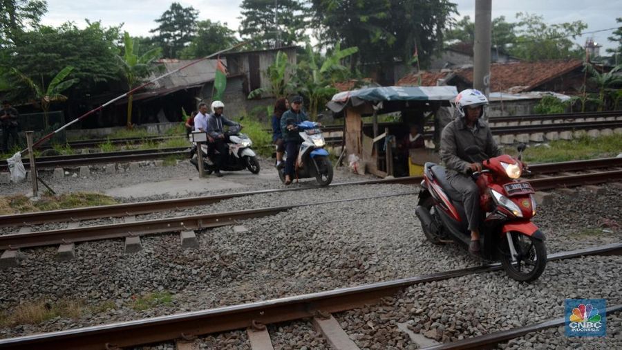Ibu Sri Wiyani (60) seorang penjaga pintu kereta api saat ditemui di kawasan Klender, Jakarta Timur, Kamis (4/1/2018). Pintu perlintasan yang terbuat dari bambu itu dijaga Ibu Sri sejak tahun 1983.
