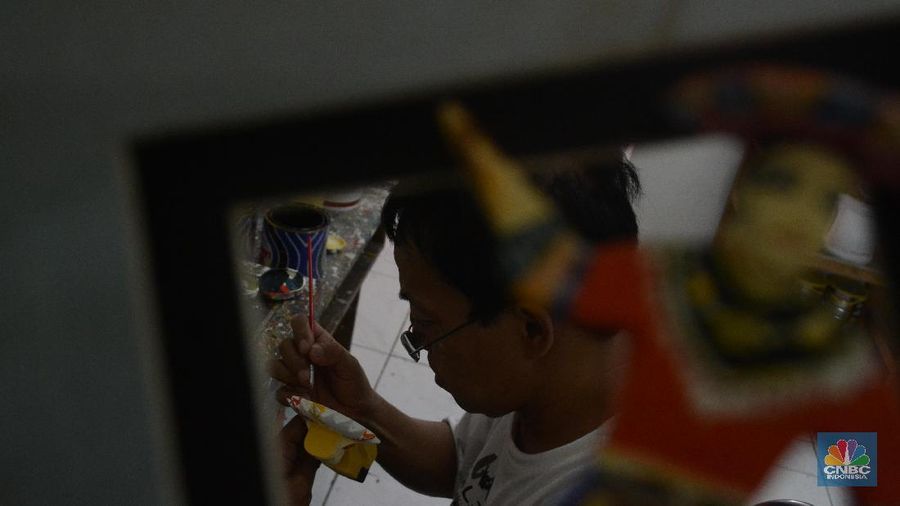 Seorang difabel melukis kerajinan miniatur Ondel-ondel di Panti Sosial Loka Bina Karya, Jagakarsa, Jakarta Selatan.