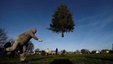 Seorang pria berpartisipasi dalam kompetisi lempar pohon natal di kota Ennis, Irlandia. (Reuters/Clodagh Kilcoyne)