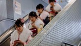 Perempuan-perempuan Jepang yang mengenakan kimono menggunakan eskalator di stasiun bawah tanah Tokyo, Jepang, setelah mengikuti perayaan Akil Baligh. (Reuters/Kim Kyung-Hoon)