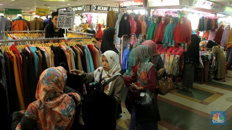 Pengunjung memilih busana muslim yang di jual di sentra perdagangan tekstil, Pasar Tanah Abang, Jakarta, Minggu (14/1/2018). Beragam model busana muslim di tawarkan dengan kisaran harga Rp 180.000 hingga Rp 350.000. Soal banyaknya lapak penjual baju secara online, pedagang justru merasa diuntungkan, karena tak sedikit pelanggannya yang saat ini menjadi reseller secara online.