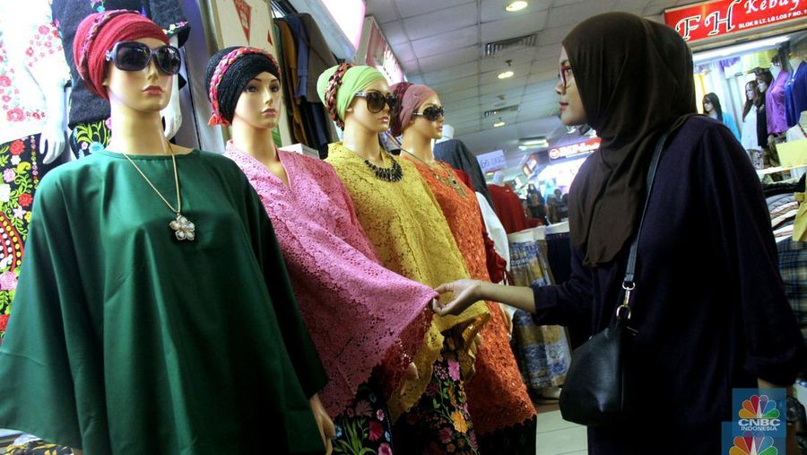 Pengunjung memilih busana muslim yang di jual di sentra perdagangan tekstil, Pasar Tanah Abang, Jakarta, Minggu (14/1/2018). Beragam model busana muslim di tawarkan dengan kisaran harga Rp 180.000 hingga Rp 350.000. Soal banyaknya lapak penjual baju secara online, pedagang justru merasa diuntungkan, karena tak sedikit pelanggannya yang saat ini menjadi reseller secara online.