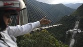 Para pekerja sedang sibuk mengerjakan proyek di atas salah satu jembatan di Kolombia pada Senin (15/1) ketika tiba-tiba jalur penyambung itu ambruk, menewaskan sepuluh orang di antara mereka. (AFP Photo/Raul Arboleda)