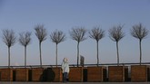 Seorang perempuan berdiri menikmati sinar matahari pada hari yang dingin di Kiev, Ukraina. (REUTERS/Valentyn Ogirenko)