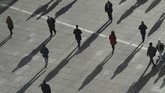 Bayangan orang-orang di bawah matahari musim dingin terlihat di plaza Canary Wharf, suatu distrik bisnis di London, Inggris. (REUTERS/Dylan Martinez)