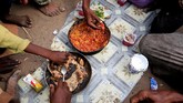 Keluarga Ruzaiq makan bersama di luar gubuk mereka, di sebelah tempat pembuangan sampah di Kota Hudaidah, Yaman, yang dikuasai pemberontak Houthi. (REUTERS/Abduljabbar Zeyad)
