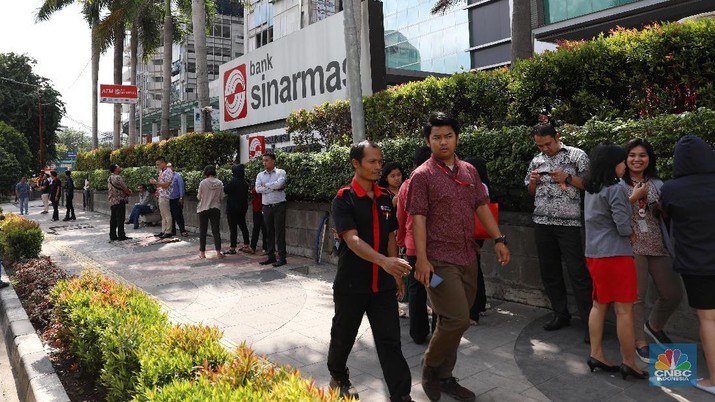Ratusan Karyawan Bank Sinarmas berada diluar gedung usai merasakan gempa di Jakarta, Selasa (23/1/2018)
