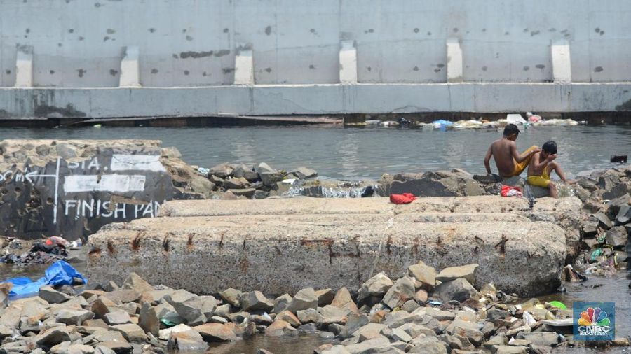 Sejumlah bocah bermain di depan pembangunan Giant Sea Wall, Jakarta, Selasa (23/1/2018)