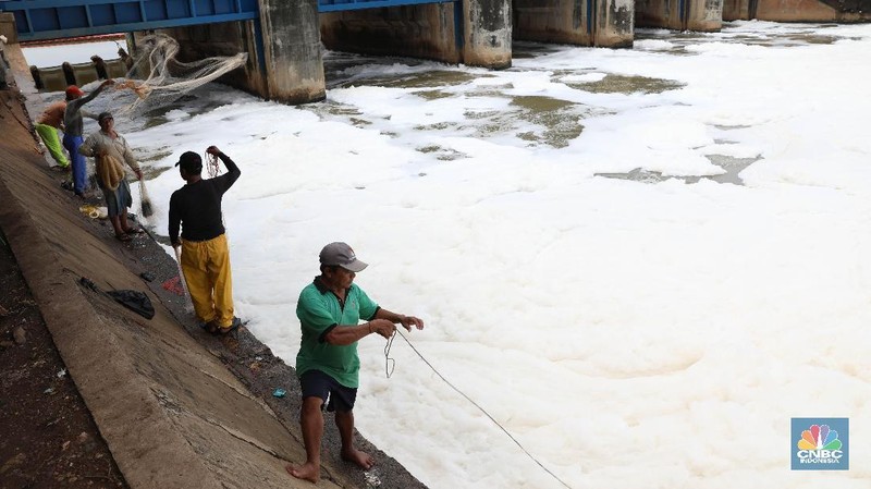 Sejumlah warga banyak menghabiskan waktu mereka dengan mencari ikan menggunakan jala di Pintu Air Weir 3 Marunda dengan kondisi air berbusa limbah rumah tangga.